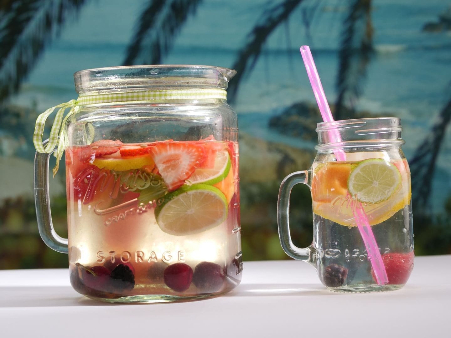 Cool off with fruit-infused water in mason jars, perfect for a sunny beach day.