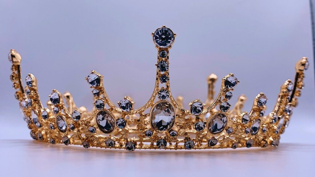 a gold crown with black and white stones