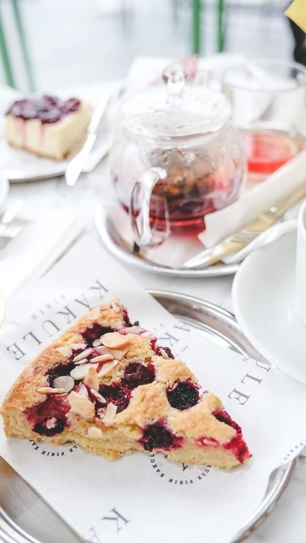 A tasty slice of berry tart served on a table with tea, perfect for a cozy afternoon.